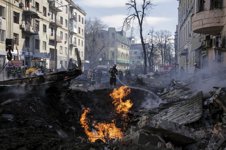 Petugas pemadam kebakaran memadamkan sebuah rumah apartemen setelah serangan roket Rusia di Kharkiv, kota terbesar kedua di Ukraina, Senin (14/3/2022). 

