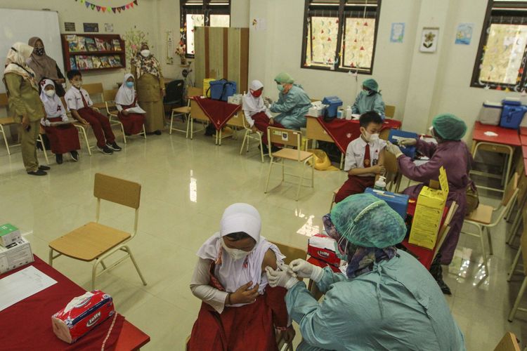 Tenaga kesehatan menyuntikan vaksinasi Covid-19 kepada siswa di SDN 01 Depok, Depok, Jawa Barat, Selasa (14/12/2021). Kementerian Kesehatan mulai memberikan vaksinasi Covid-19 untuk usia 6-11 tahun dengan penggunaan vaksin Sinovac di beberapa sekolah di daerah Jakarta, Depok dan Tangerang Selatan.