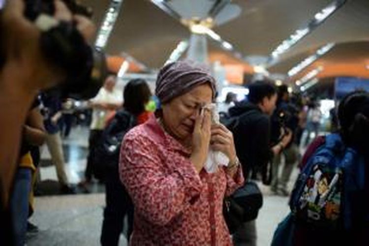Seorang wanita menangis di dekat pusat informasi Malaysia Airlines di Bandara Internasional Kuala Lumpur di Sepang, malaysia, Jumat (18/7/2014).