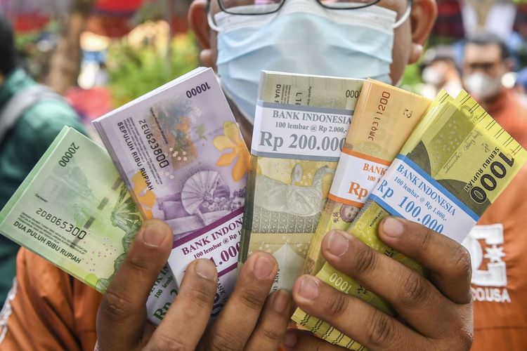 Ilustrasi warga menunjukan uang baru usai ditukarkan di mobil kas keliling Bank Indonesia (BI). Simak lokasi penukaran uang baru di kas keliling dan titik perbankan di wilayah Bantul selama bulan Ramadhan 2024