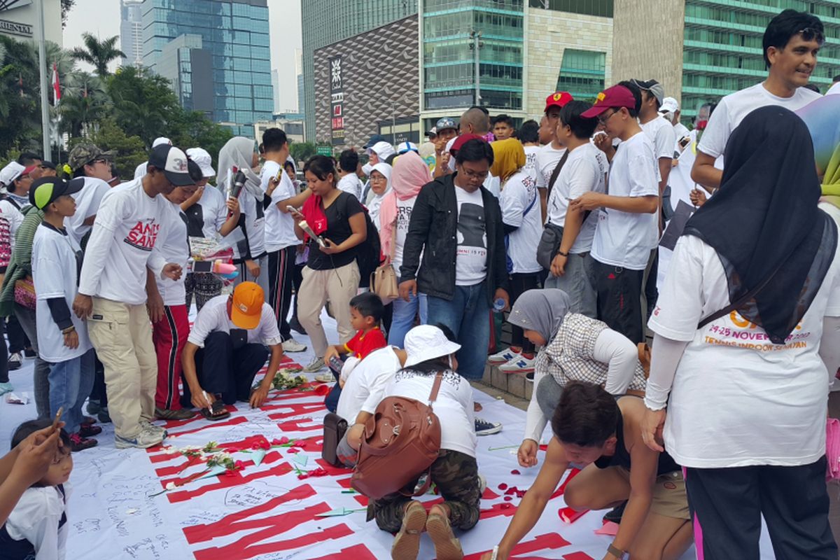 Relawan pasangan gubernur dan wakil gubernur DKI Jakarta terpilih Anies Baswedan-Sandiaga Uno, Roemah Djoeang, menandatangani spanduk di Bundaran HI, Minggu (7/5/2017), sebagai harapan agar Anies-Sandi memenuhi janji mereka.