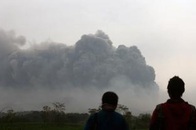Seorang warga menyaksikan erupsi Gunung Kelud, Kabupaten Kediri, Jumat (14/2/2014). Gunung Kelud meletus pada Kamis (13/2/2014) pukul 22.50 WIB. Gunung itu menyemburkan material berupa kerikil dan abu hingga ketinggian 17 kilometer.