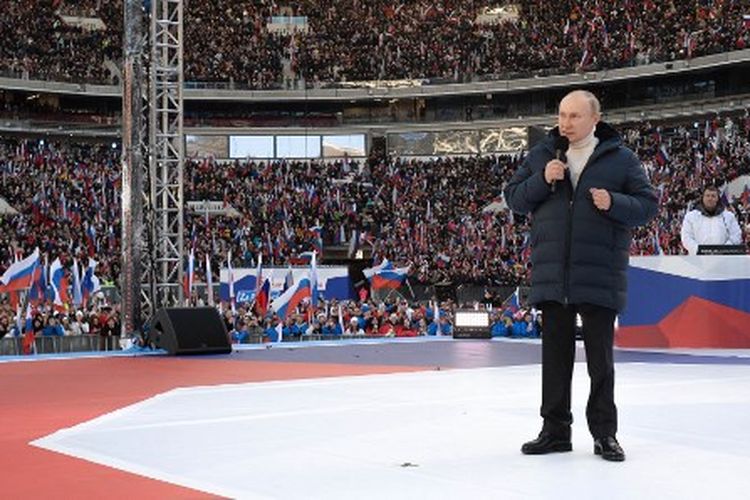 Presiden Rusia Vladimir Putin memberikan pidato pada konser yang menandai ulang tahun kedelapan pencaplokan Crimea oleh Rusia di stadion Luzhniki di Moskow pada Jumat (18/3/2022).