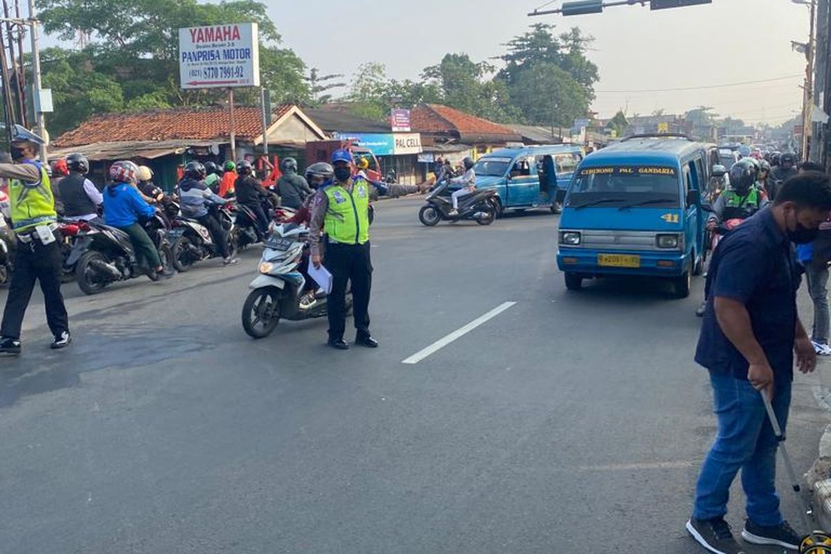 Unit Laka Lantas Polres Metro Depok tengah mengecek lokasi pejalan kaki yang tewas terlindas minibus di Jalan Raya Bogor, Cimanggis, Depok, Senin (22/5/2023).