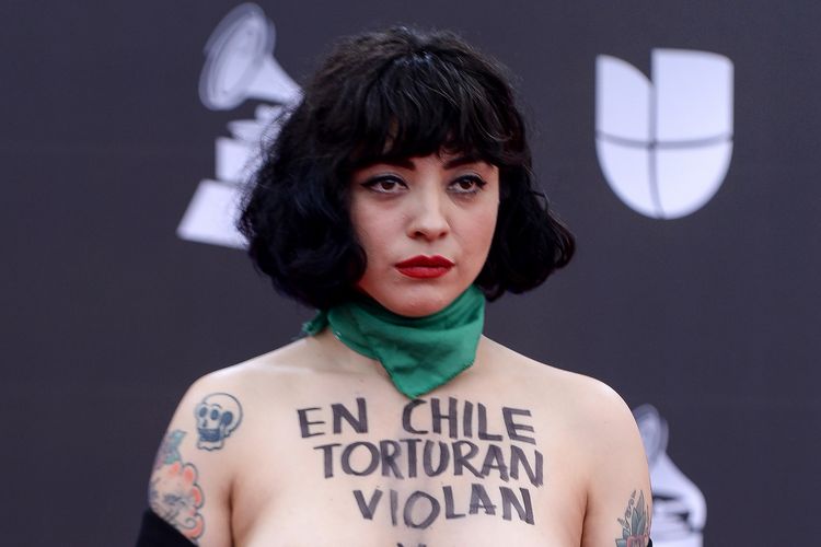 Penyanyi Chile Mon Laferte tampil telanjang dada ketika menghadiri penghargaan Latin Grammy di Las Vegas, Amerika Serikat, pada 14 November 2019. Terdapat tulisan yang berarti Di Chile, mereka memperkosa, membunuh, dan menyiksa.