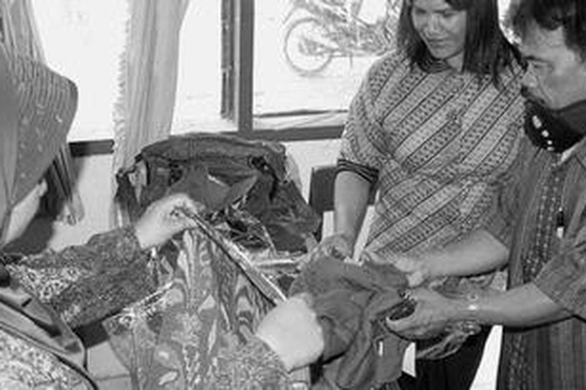 Remsina br Manalu (tengah), guru bantu pengganti di SD 101996 Baturata, Desa Sialang, Kecamatan Bangun Purba, Kabupaten Deli Serdang, Sumatera Utara, memperlihatkan dagangan kepada rekan-rekannya di kantor sekolah itu, Sabtu (3/2). Remsina terpaksa berdagang karena honornya sebagai guru bantu sebesar Rp 150.000 per bulan tidak cukup untuk memenuhi kebutuhan hidup sehari-hari.