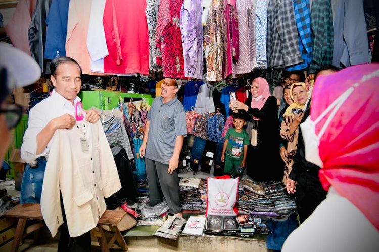 Presiden Joko Widodo saat membeli baju koko di Pasar Petanahan di Kabupaten Kebumen, Provinsi Jawa Tengah, Kamis (9/3/2023)