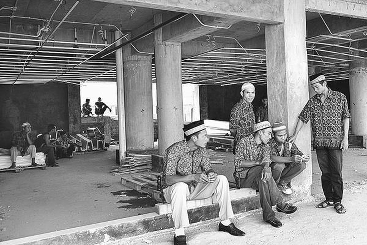 Sejumlah pekerja venue SEA Games di Jakabaring, Palembang, menunggu jemputan untuk mengantarkan mereka ke Griya Agung, Rabu (31/8). Gubernur Sumatera Selatan Alex Noerdin mengundang mereka untuk bersilaturahim (open house) di kediamannya.