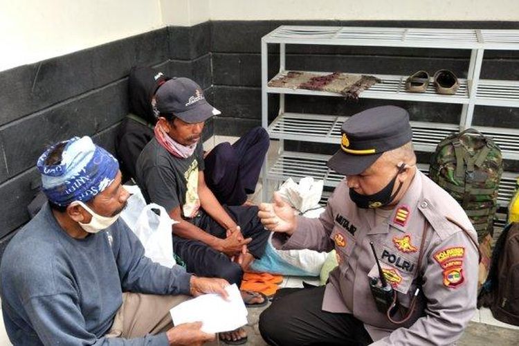 Kasiwas Polresta Bandar Lampung AKP Mutajir berbincang dengan warga Desa Cinangsi, Kecamatan Cisitu, Kabupaten Sumedang, Jawa Barat yang telantar di Bandar Lampung, Selasa (6/4/2021). 
