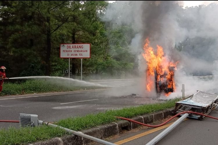 Mobil Toyota Alphard terbakar setelah terguling akibat menabrak tiang lampu di di arah pintu masuk Tol Bintaro Xchange, Pondok Aren, Tangerang Selatan, Senin (27/11/2023).