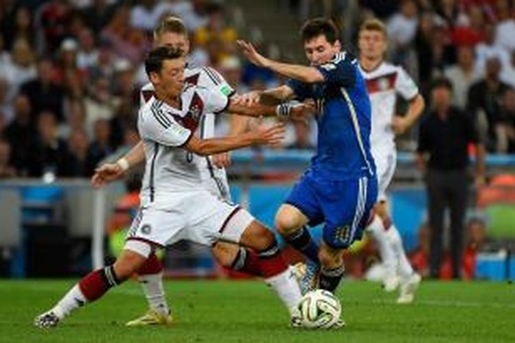 Gelandang tim nasional Jerman, Mesut Oezil saat ingin merebut bola dari kaki bomber Argentina, Lionel Messi, pada laga final Piala Dunia 2014 di Stadion Maracana, Minggu (13/7/2014).