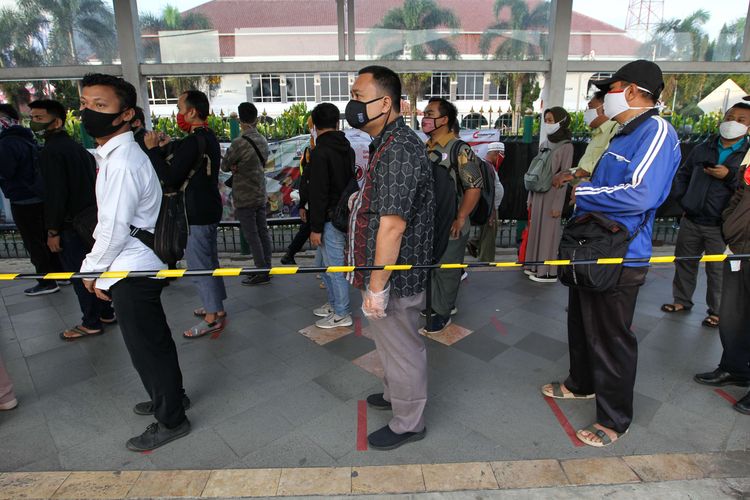 Calon penumpang Kereta Rel Listrik (KRL) Commuter Line antre di Stasiun Kota Bogor, Selasa (9/6/2020). Pihak stasiun menerapkan protokol kesehatan kepada para penumpang antara lain penerapan pembatasan jumlah kapasitas penumpang di dalam gerbong KRL.