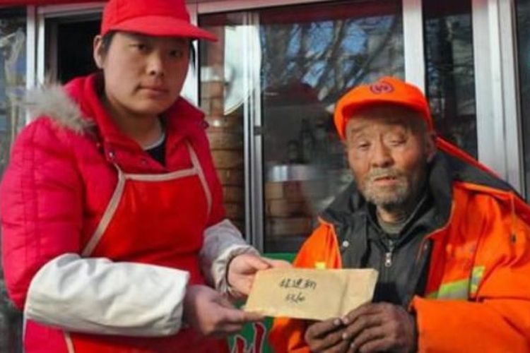 Liu saat memberikan amplop berisi uang bantuan warga untuk pembersih jalan renta Cheng Yanxin (70) yang kehilangan uang gajinya.