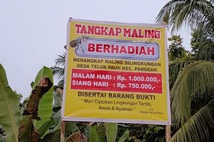 Spanduk sayembara tangkap maling berhadiah sebelum dicopot terpampang di lingkungan Desa Teluk Pauh, Kecamatan Pangean, Kabupaten Kuantan Singingi, Riau, Jumat (16/9/2022).
