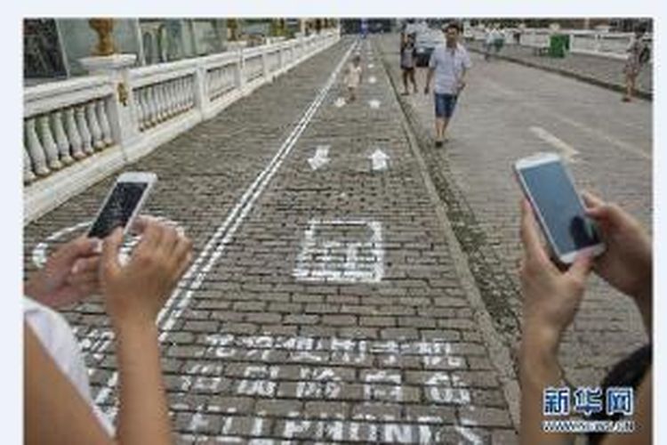 Bentangan trotoar sepanjang 100 kaki ini disulap menjadi jalur khusus untuk orang dengan mata yang selalu tertuju ke layar ponselnya. Jalur ini memiliki gambar telepon yang terukir di tanah.  