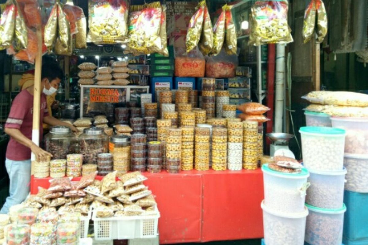 Pedagang kue kering, Robianto (22) sedang merapihkan toples kue yang dijajakan di Pasal Kramat Jati, Jakarta Timur