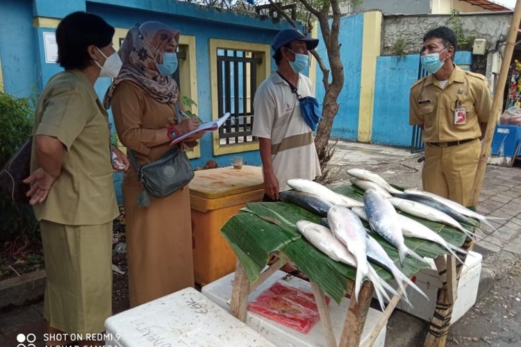 Petugas sudin KPKP Jakarta Barat mengecek penjual ikan bandeng di Jalan Sulaiman Pasar Rawa Belong, pada Selasa (9/2/2021).