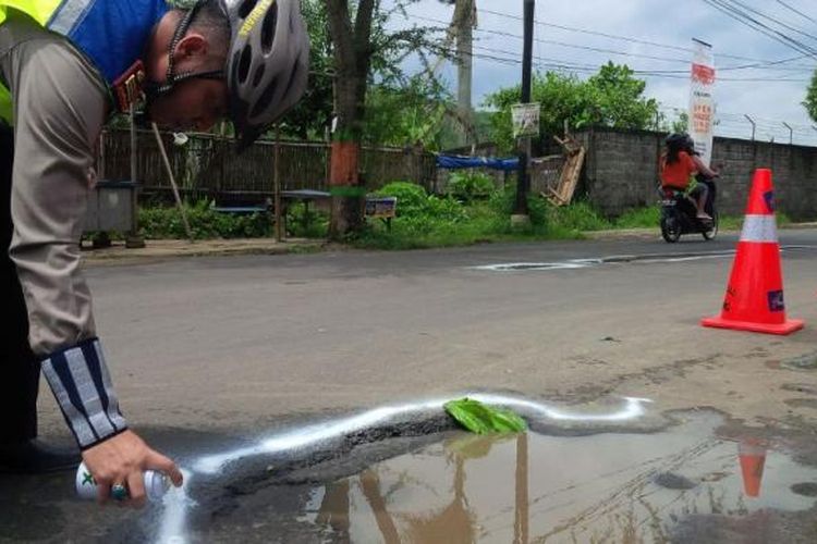 Kasatlantas Polres Semarang AKP Dwi Nugroho tengah menandai lubang jalan di Jl MT Hariyono No 50, Kalirejo, Ungaran, Kabupaten Rabu (1/2/2017) siang.