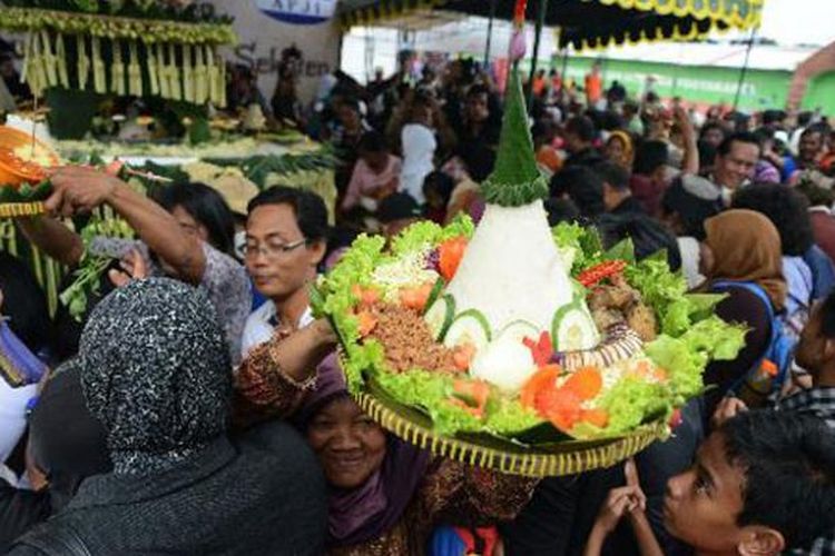 Warga berdesakan berusaha mengambil tumpeng dan makanan dalam acara Dhahar Kembul Sego Gurih yang digelar dalam arena Pasar Malam Perayaan Sekaten di Alun-alun Utara, Yogyakarta, Selasa (7/1/2014). Acara tersebut digelar antara lain untuk mempopulerkan kembali nasi gurih dan telur merah sebagai makanan khas dalam perayaan Sekaten.