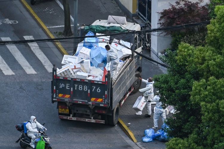 Pekerja kebersihan mengenakan alat pelindung diri (APD) selama lockdown Covid-19 di distrik Jing'an di Shanghai pada 20 April 2022.