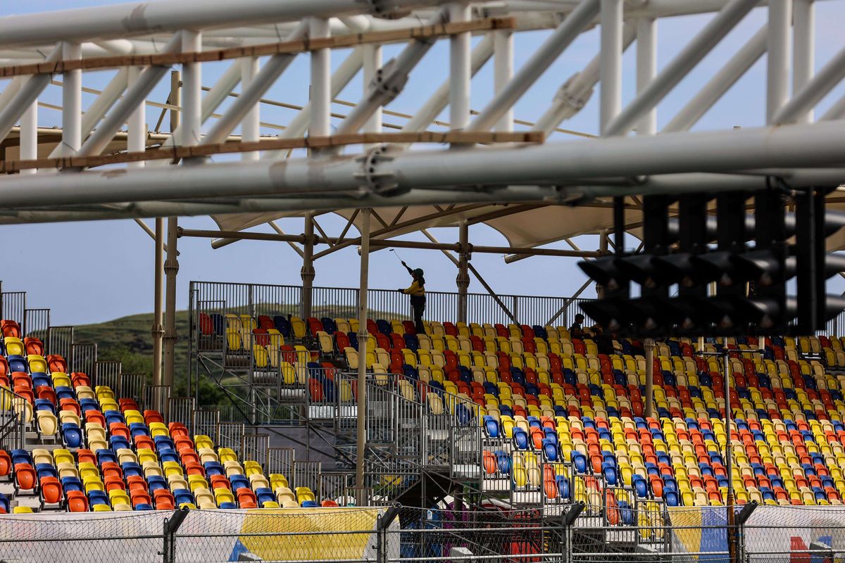 Para pekerja menyelesaikan pengecatan tiang disekitar bangku penonton kategori premium grandstand yang berada di depan area paddock Sirkuit Internasional Jalan Raya Pertamina Mandalika di Kuta, Pujut, Lombok Tengah, Nusa Tenggara Barat, Senin (14/3/2022). Tribune penonton yang disediakan untuk ajang MotoGP pada 18-20 Maret 2022 terbagi dalam beberapa kategori dengan 62.000 tempat duduk.