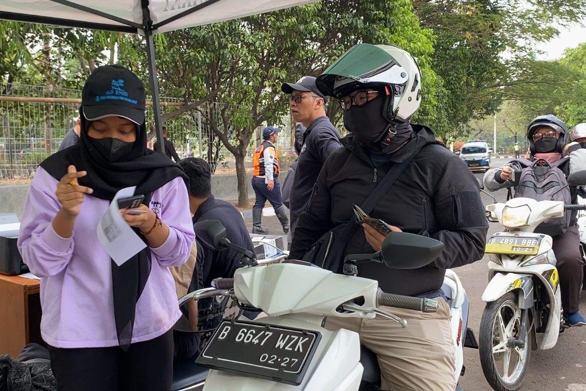Pengendara motor berbaris untuk mengikuti tilang uji emisi di Jakarta Barat