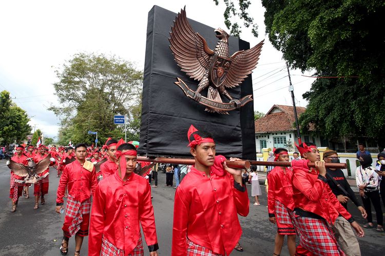 Sejumlah siswa dan budayawan membawa lambang Garuda Pancasila saat Kirab Prosesi Gerebeg Pancasila di Kota Blitar, Jawa Timur, Rabu (1/6/2022). Kirab Prosesi Grebeg Pancasila tersebut  merupakan tradisi masyarakat setempat dalam memperingati Hari Lahir Pancasila.