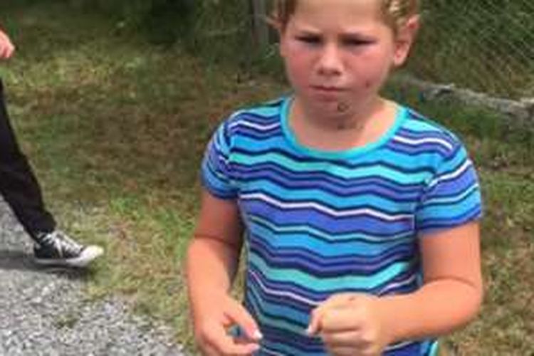 Anak berkaus biru yang terkena lemparan tinja dari seekor babun di kebun binatang North Carolina, AS.