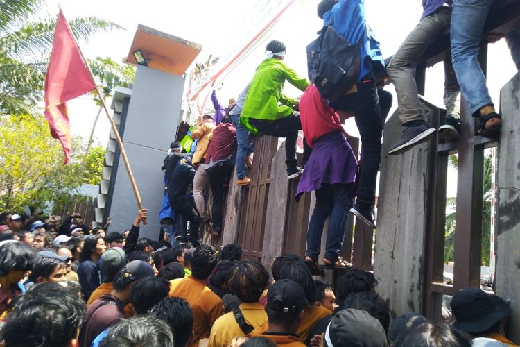 Mahasiswa memaksa masuk areal gedung DPRD Kaltim dengan memanjat gerbang, Senin (23/9/2019). 