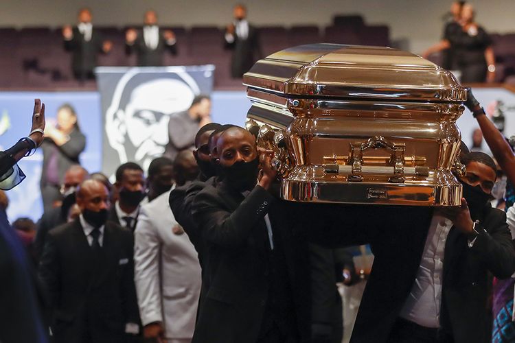 Pallbearer mengangkat peti mati George Floyd saat upacara pemakaman di Gereja The Fountain of Praise di Houston, AS,  Selasa (9/6/2020). Ribuan pelawat baik di dalam tempat penghormatan terakhir hingga di jalanan menuju area pemakaman berbaris seiring peti berlapis emas yang membawa jasad Floyd dibawa menggunakan kereta kuda.