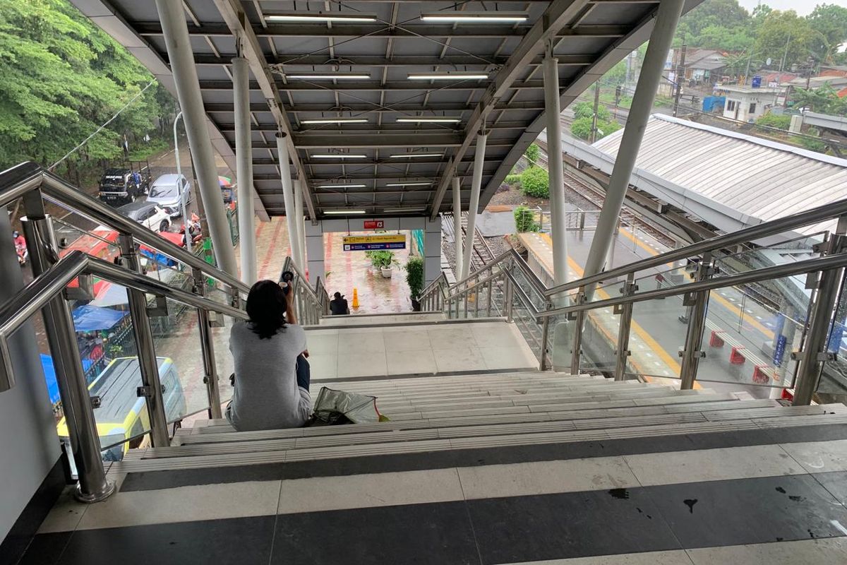 Salah satu penumpang, Rianti (43) tengah duduk di anak tangga stasiun Cakung setelah lelah melewati 45 anak tangga, Senin (29/1/2024).