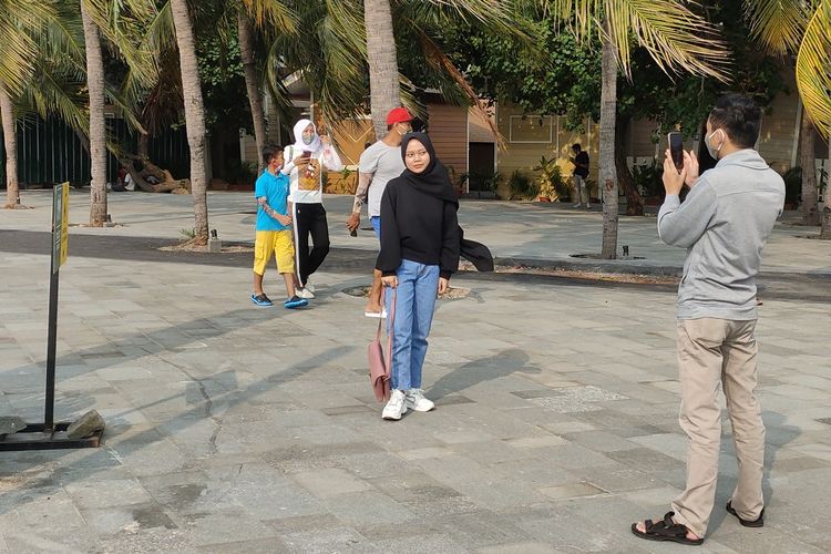 Pengunjung melakukan aktivitas berfoto di pantai Ancol, Sabtu (27/6/2020). Pengunjung pantai Ancol melakukan ragam aktivitas menarik lainnya karena tidak boleh berenang di pantai selama masa pandemi.