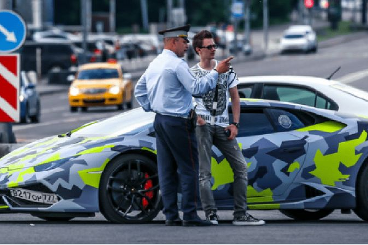 Maksim Yakubets mengendarai mobil Lamborghini dengan kata pencuri dalam bahasa Rusia di plat nomornya.
