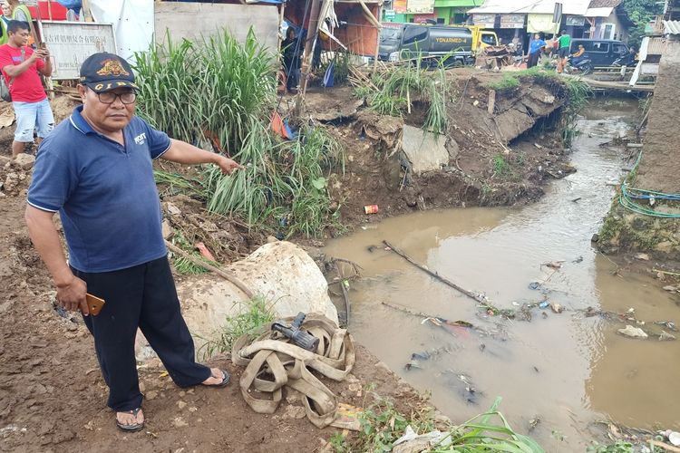 Seorang warga Kampung Lebaksari, Desa Mekarsari, Kecamatan Ngamprah, Kabupaten Bandung Barat tengah menunjukkan pusat luapan aliran Sungai Ciburandul yang menyebabkan banjir dua hari lalu.
