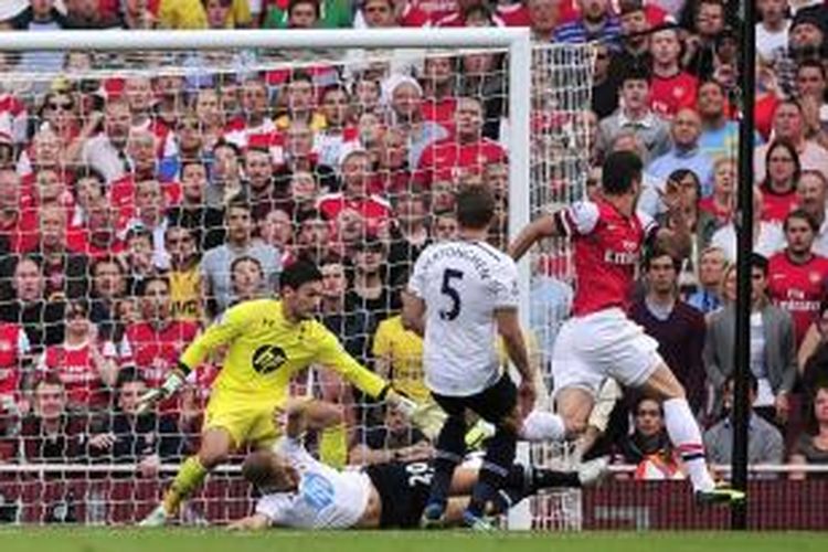 Penyerang Arsenal, Olivier Giroud (kanan), melepaskan tembakan yang berujung gol ke gawang Tottenham Hotspur, pada lanjutan Premier League, di Emirates, Minggu (1/9/2013).