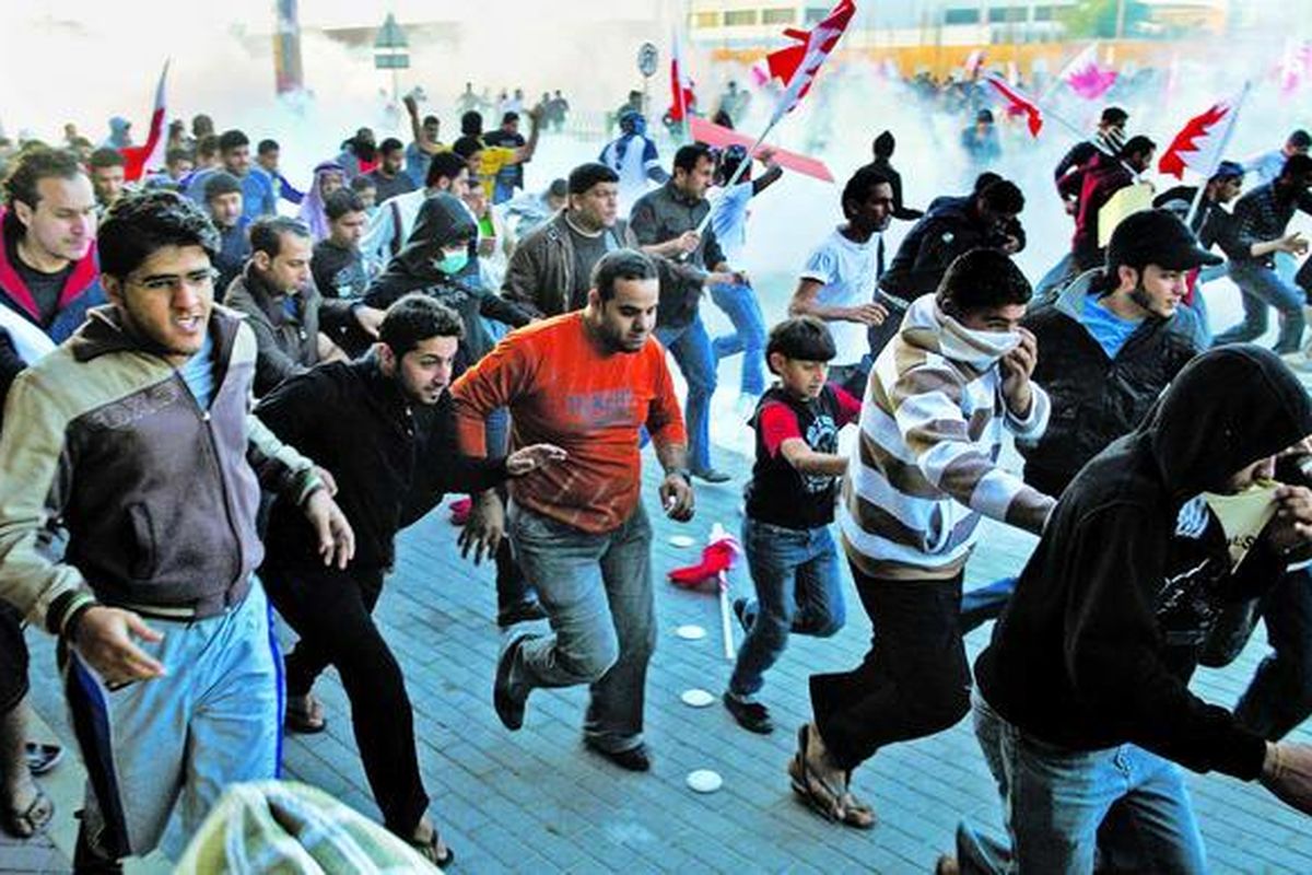 Pengunjuk rasa Bahrain berlari menghindari gas air mata yang dilemparkan polisi untuk membubarkan mereka di Desa Sanabis, dekat Manama, Senin (14/2). Unjuk rasa ini diinspirasi oleh gerakan serupa di Tunisia dan Mesir.