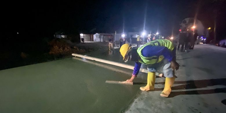 Pekerja konstruksi sedang melakukan pekerjaan perbaikan di Jalan Raman Nirwana, Lampung Tengah, Kamis (26/10/2023) malam.