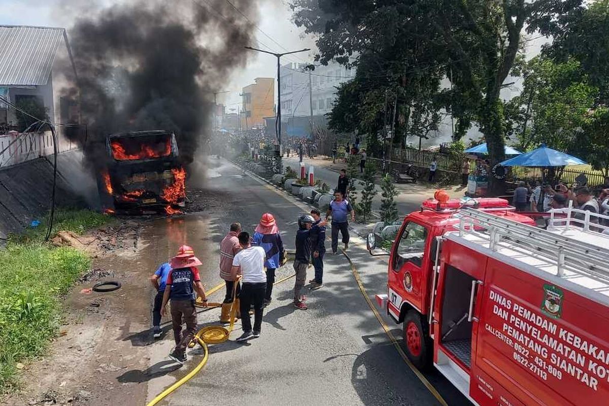 Petugas Damkar memadamkan Bus Nice Trans yang terbakar di Jalan Sisingamangaraja, Kelurahan Sigulang gulang, Kecamatan Siantar Utara, Kota Pematang Siantar, Provinsi Sumatera Utara (Sumut), Sabtu (9/12/2023)