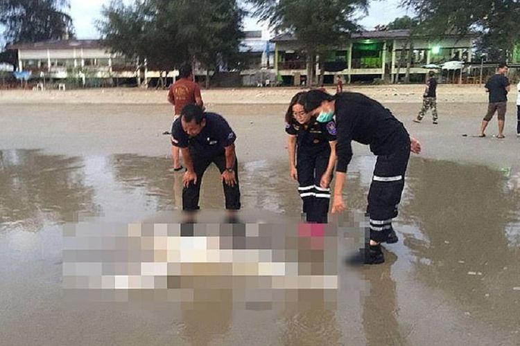 Polisi memperhatikan mayat tanpa kepala berjenis kelamin pria yang ditemukan di pantai kawasan pariwisata Thailand.