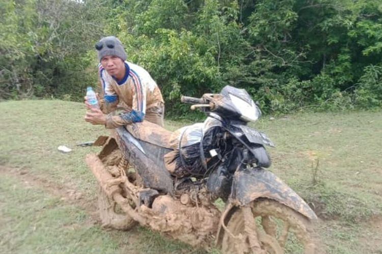 Pak Hamsul, guru di SD di Kepulauan Sumenep bersama motor yang dikendarainya penuh lumpur