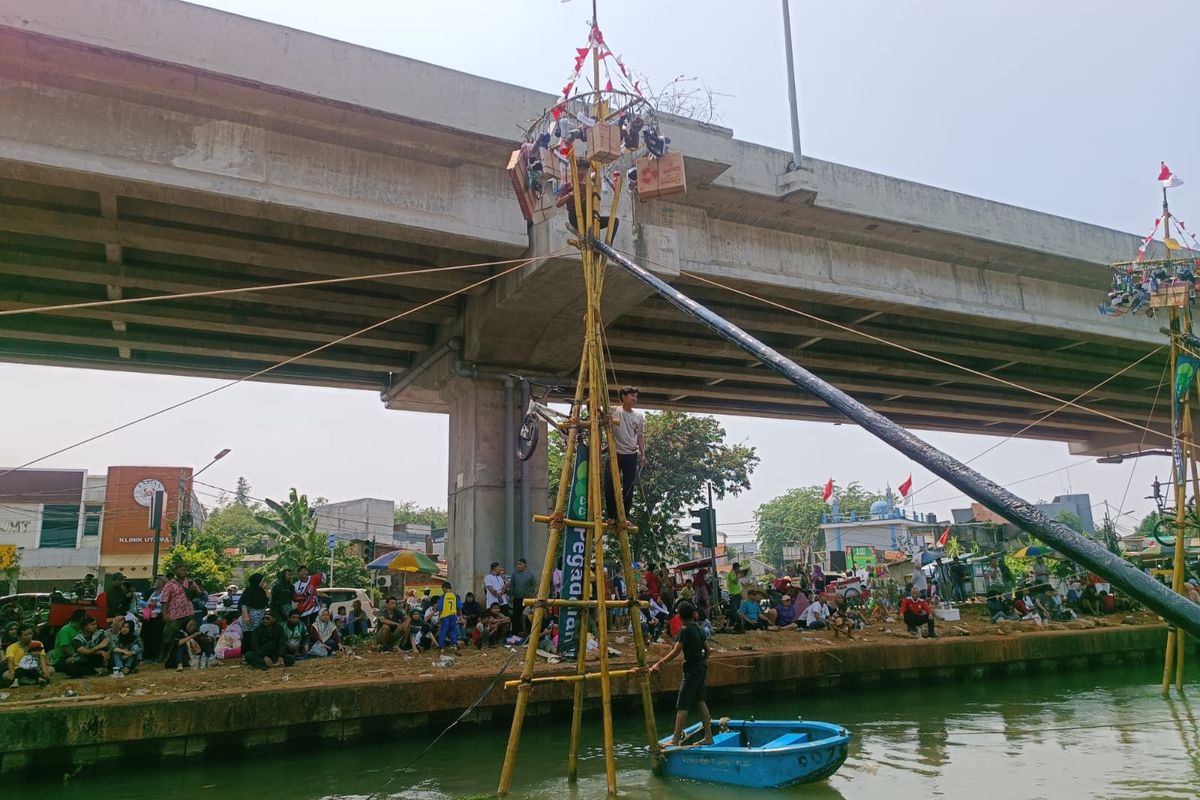 Panjat pinang emas di Kalimalang, Cipinang Melayu, Makasar, Jakarta Timur, Minggu (20/8/2023).