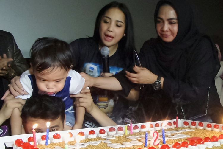 Rafathar Malik Ahmad meniup lilin ulang tahun, ditemani oleh kedua orangtuanya, Nagita Slavina atau Gigi dan Raffi Ahmad, serta ibu Gigi, Rieta Amalia, di Setiabudi One XXI, Kuningan, Jakarta Selatan, Selasa (15/8/2017).