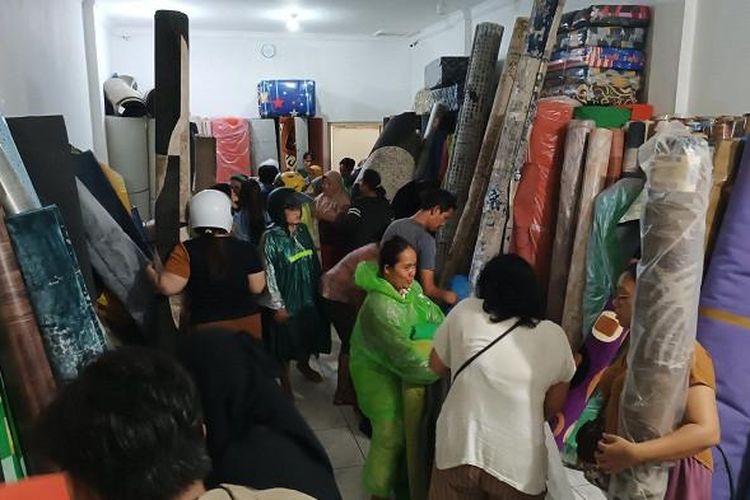 Pedagang yang berada di Jalan Gajah Mada, Denpasar, Bali mengobral murah dagangannya usai terendam banjir besar beberapa waktu lalu.