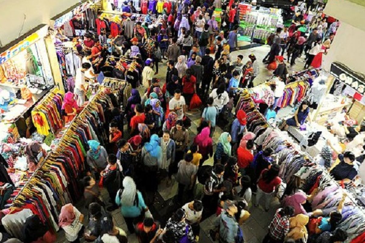 Pengunjung memadati kawasan pusat grosir Pasar Tanah Abang, Jakarta Pusat, Minggu (18/6). Warga memanfaatkan hari libur untuk berbelanja berbagai kebutuhan satu minggu menjelang Idul Fitri. 