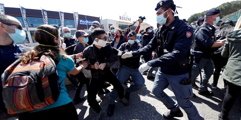 Polisi menahan gerak massa yang berdemonstrasi di luar penjara Rebibbia. Demonstran menuntut lingkungan yang lebih bersih di dalam penjara, di tengah merebaknya pandemi virus corona di Italia. Foto diambil pada 16 April 2020.