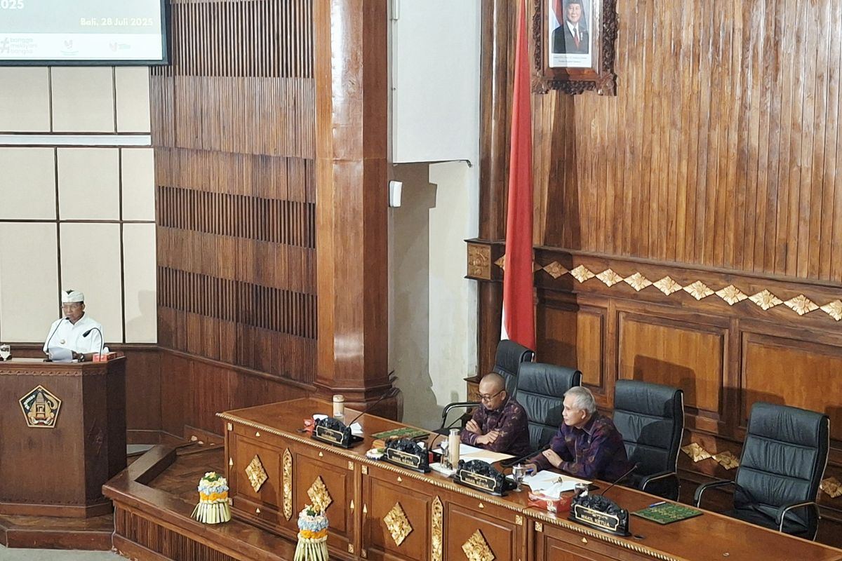 Gubernur Bali Wayan Koster saat berbicara dalam rapat paripurna bergendakan jawaban gubernur atas pandangan umum fraksi-fraksi DPRD Bali terhadap Raperda tentang Perubahan APBD Semesta Berencana Provinsi Bali Tahun Anggaran 2025, di Wiswa Sabha Utama Kantor Gubernur Bali, pada Senin (28/7/2025). KOMPAS.com/ Yohanes Valdi Seriang Ginta
