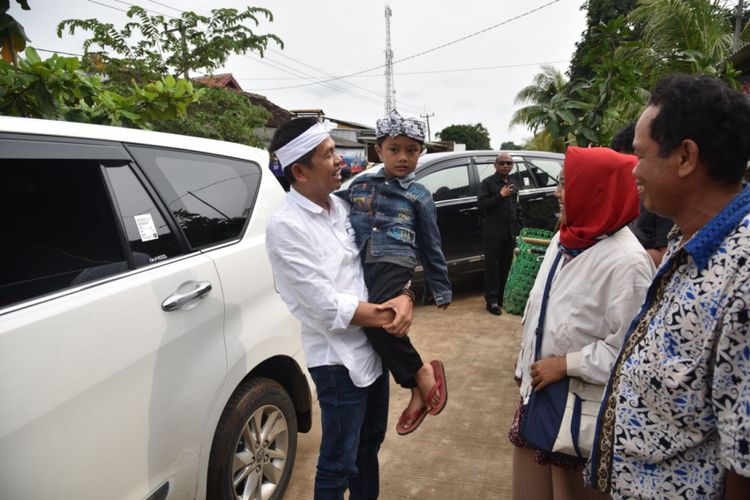 Dedi Mulyadi menggendong seorang bocah asal Karawang yang ingin bertemu dirinya di Kecamatan Lemahabang, Karawang, Jumat (23/2/2018).