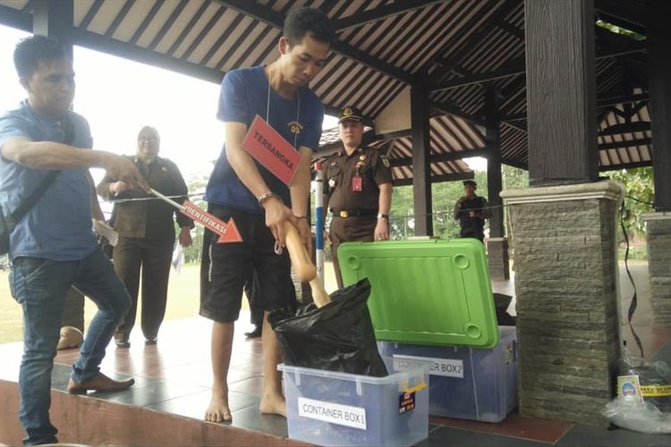 Tersangka DP (37) memperagakan adegan mutilasi terhadap KW (51) di kompleks Mapolres Banyumas, Jawa Tengah, Selasa (30/7/2019).