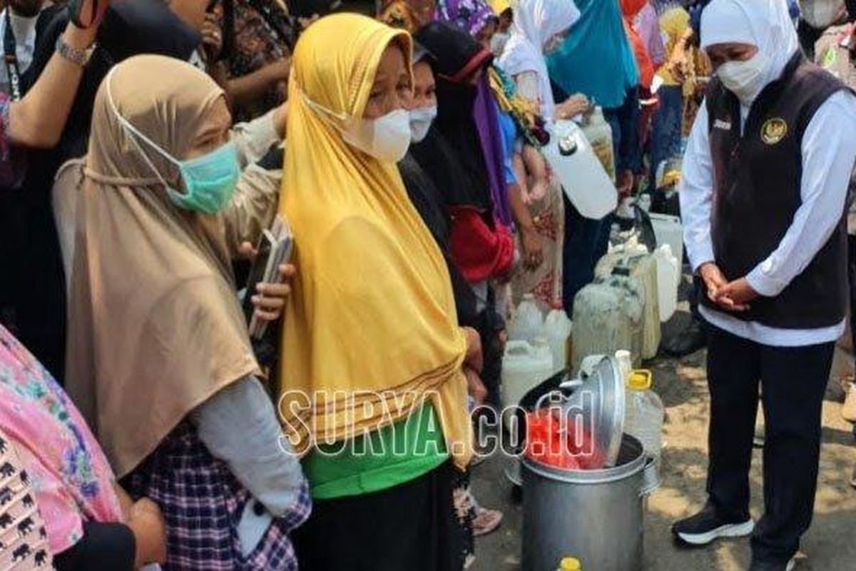 Gubernur Jawa Timur Khofifah Indar Parawansa saat mengobrol dengan pedagang yang antre minyak goreng murah dengan membawa dandang nasi besar. 