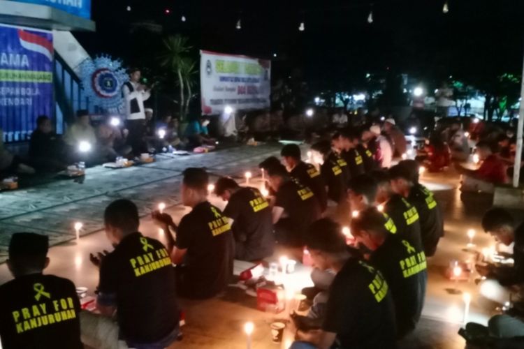 Ratusan pencinta sepakbola di Kendari mengelar doa bersama untuk korban tragedi Kanjuruhan Malang di tugu persatuan Kendari, Selasa (4/10/2022). (KIKI ANDI PATI/KOMPAS.com)
